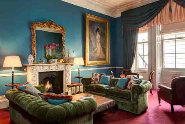 Elegant meeting space with plush green sofas at The Library at the Gore, ideal for networking.
