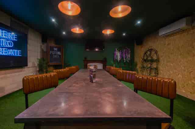 Modern meeting space with industrial table and greenery in Swansea for creative events.