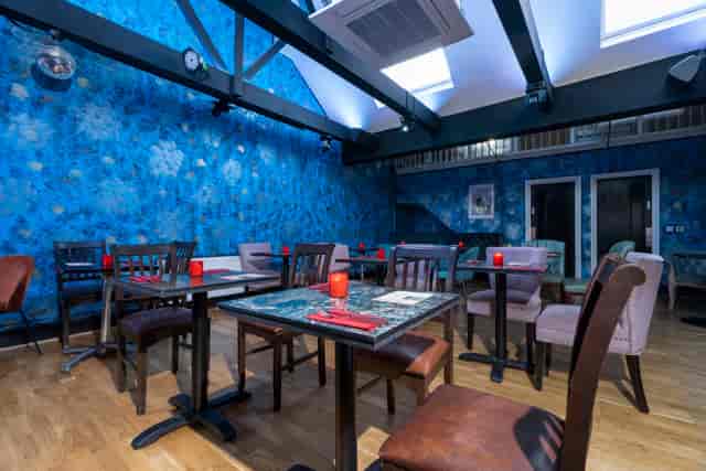 Versatile event space in Zebrano Soho with vibrant blue walls and wooden flooring.