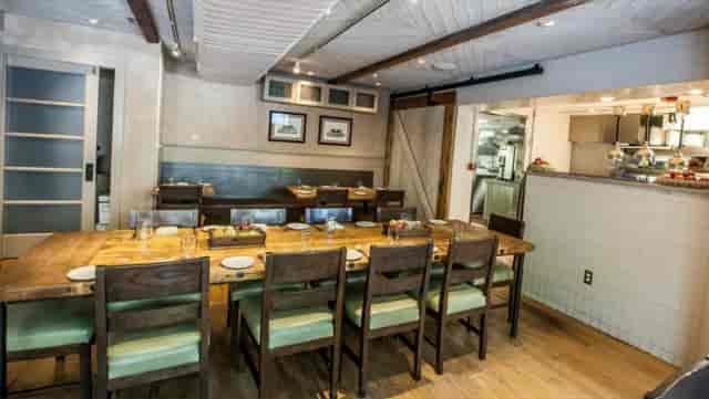 Intimate dining space with wooden table for team-building events in Agricola.