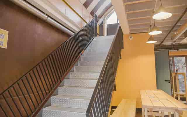 Well-lit staircase in modern industrial brewery, perfect for events and networking.