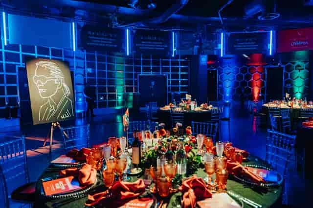 Elegant dinner setup in indigo at The O2, featuring lush centerpieces and ambient lighting.