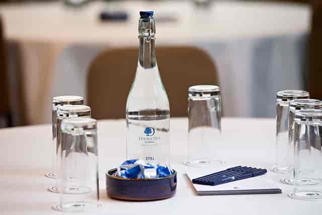 Townshend Suite meeting table with elegant setup, water bottle, and mints at DoubleTree Ealing.