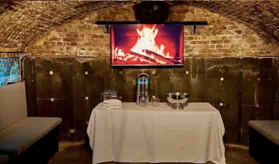 Cozy Dockside Vaults event space with digital fireplace for intimate gatherings.