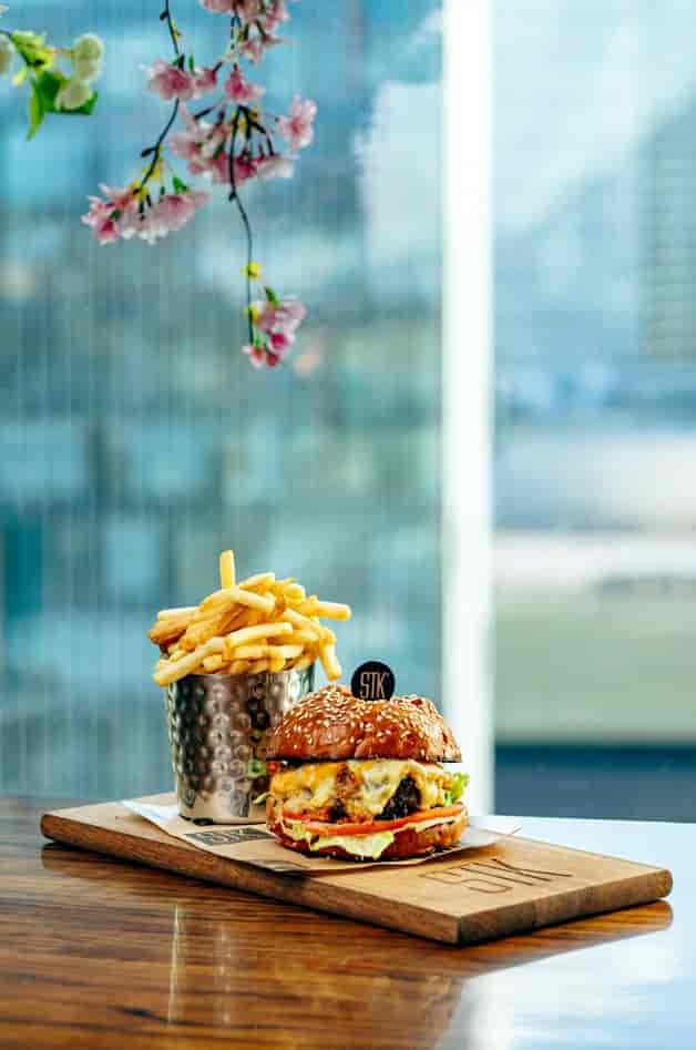 Gourmet burger with fries at STK Rooftop Stratford, perfect for upscale dining events.