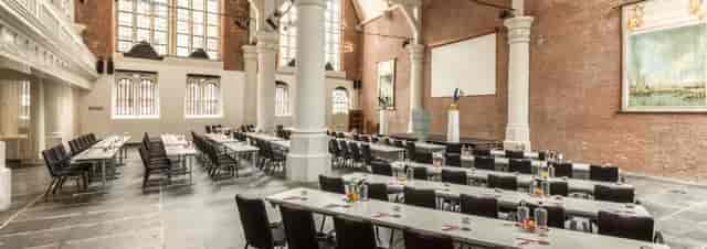 Olof's Chapelle conference venue with tables, chairs, and stage for events in Nhow Barbizon Palace.