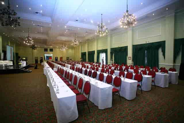 Conference setup at Indaba Hotel with white tables and red chairs for formal events.