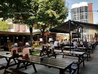 Vibrant outdoor event space with picnic tables for casual gatherings and networking.