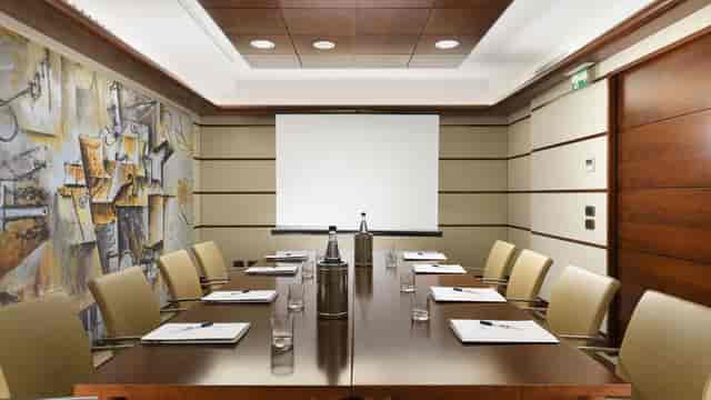 Meeting room at Una Hotels Casa Milano with wooden table, ideal for professional gatherings.
