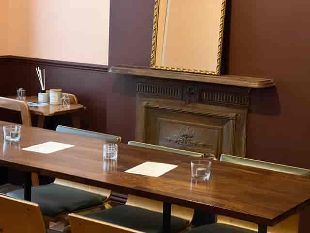 Cozy private dining room with wooden table, ideal for meetings and workshops.
