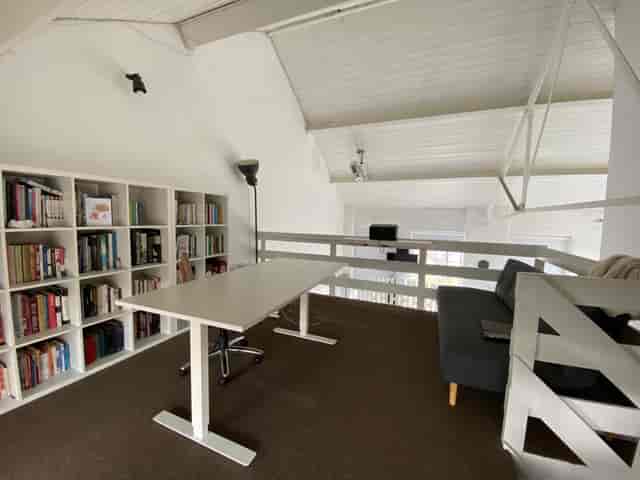Industrial loft event space in High Barnet with sleek table, ideal for meetings and brainstorming.