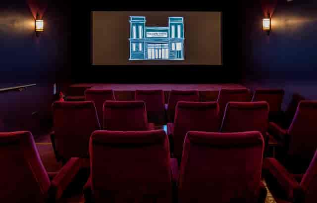 Cozy screening room with plush red seating for private film events and corporate meetings.