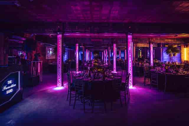 Elegant event space at Tobacco Stores, featuring round tables and vibrant lighting for corporate events.