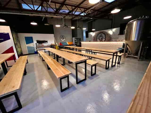 Brewery event space with wooden tables, ideal for corporate gatherings and workshops.