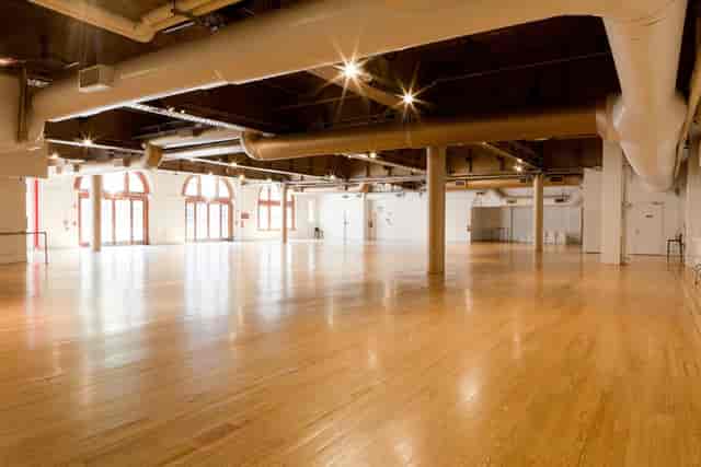 Spacious event venue with polished floors, ideal for conferences and gatherings.