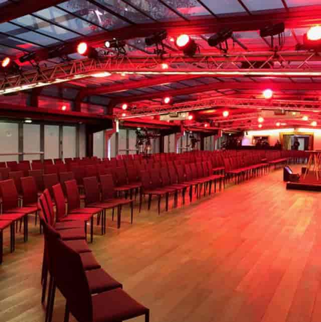 Spacious Les Salons Nework venue with red lighting for conferences and presentations.