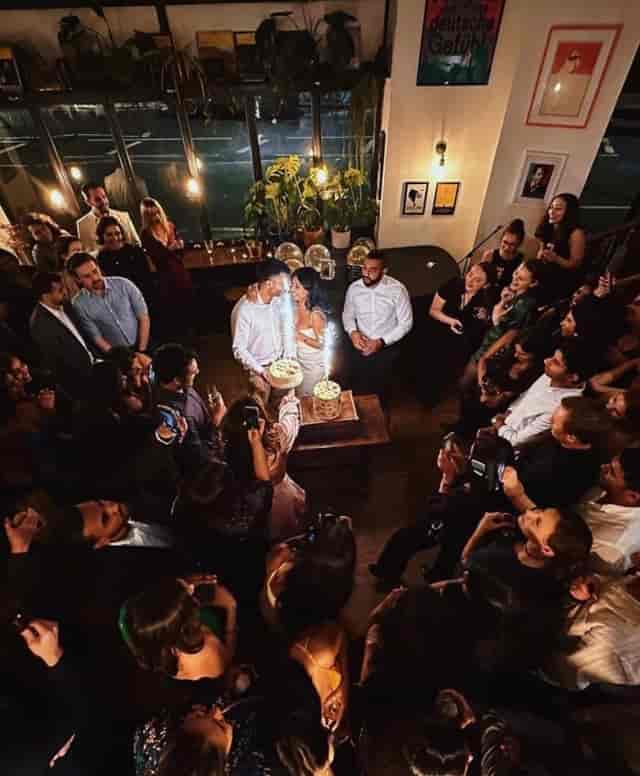 "Couple celebrating with cake at Vienna Salon event, warm ambiance and guest engagement."