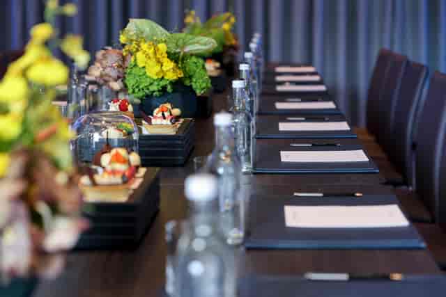 Sakura Boardroom at Nobu Hotel: elegant meeting space with floral centerpieces and desserts.
