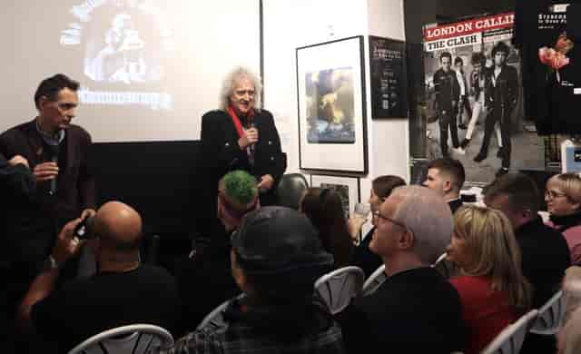 Engaging speaker at dynamic event in Proud Galleries with creative backdrop and interactive seating.