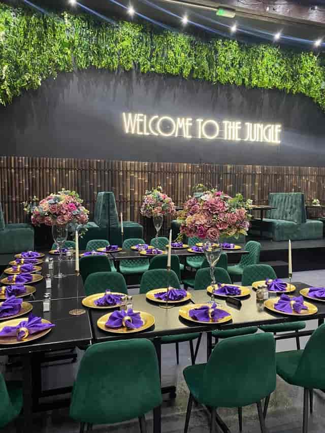 Upscale event space at Jungle Bar & Grill with floral centerpieces and neon sign.