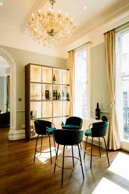 Stylish meeting space at VCLUB Whisky Lounge with elegant green chairs and whisky display.