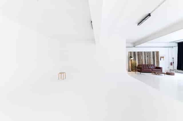 Versatile minimalist event space with natural light for workshops and gatherings.