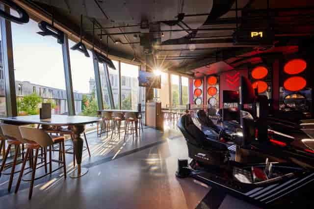 Modern event space with racing simulators, ideal for corporate gatherings and team-building.