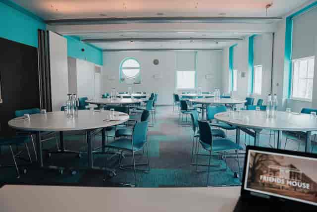 Meeting room with round tables and blue accents for workshops or conferences.