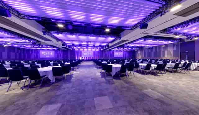Vox Birmingham conference venue with round tables and purple lighting for events.