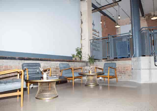 Stylish SEESAW foyer with modern seating and gold tables for networking events.
