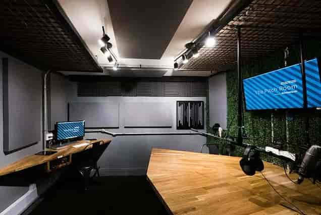 Modern pitch room with wooden table, ideal for meetings and presentations in Soho.