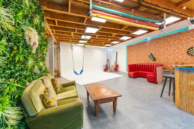 Versatile event space at 6 Degrees Studios with vibrant green wall for creative gatherings.