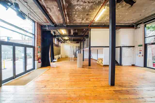 Versatile industrial event space with large windows for meetings and workshops.