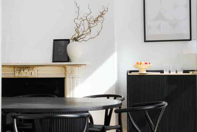 Stylish minimalist meeting room with round black table for creative gatherings.
