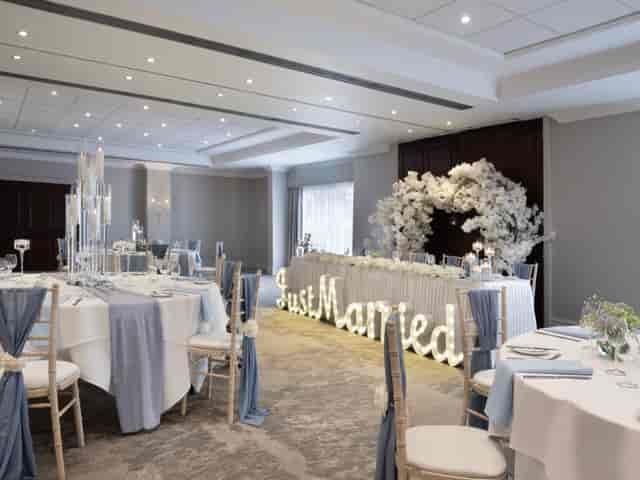 Elegant wedding reception in Worsley Suite with blue accents and floral decor.