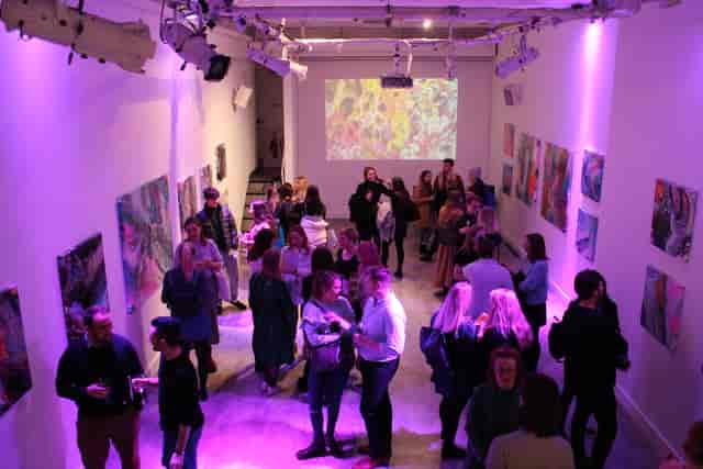 Industrial-chic art gallery event space in London with vibrant lighting for networking functions.
