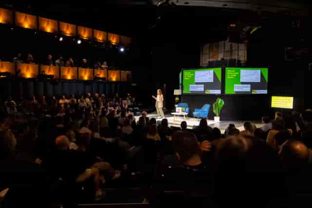 Sohoplace theatre event with speaker engaging audience in modern venue setting.