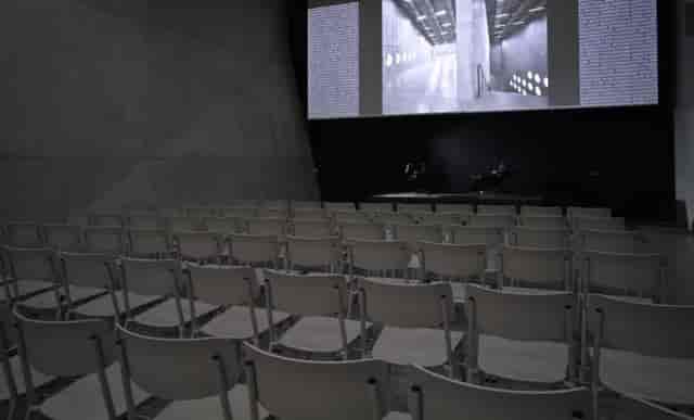 Auditorium Willy GS Hirzel: minimalist event space with empty white chairs for presentations.
