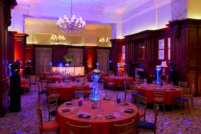 Elegant banquet room with orange linens, ideal for upscale galas and corporate dinners.