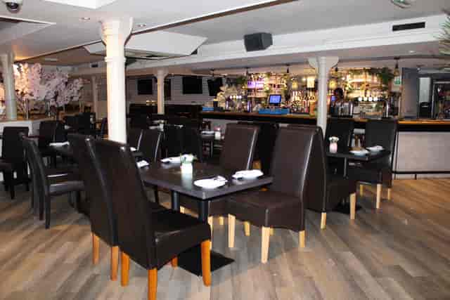 Private room in Empire Executive Lounge with dark wood tables for meetings and events.