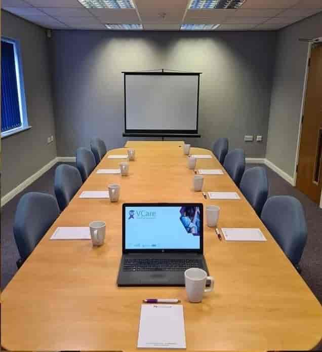 Auditorium meeting room with long table, ready for professional gatherings and presentations.