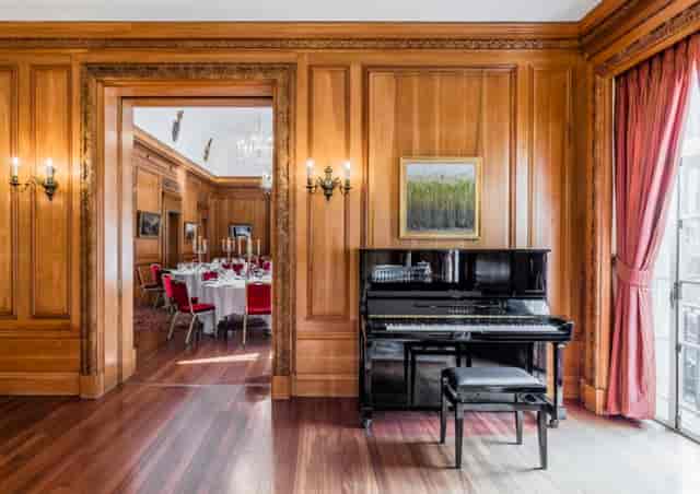 Elegant event space with grand piano, ideal for upscale receptions and corporate events.