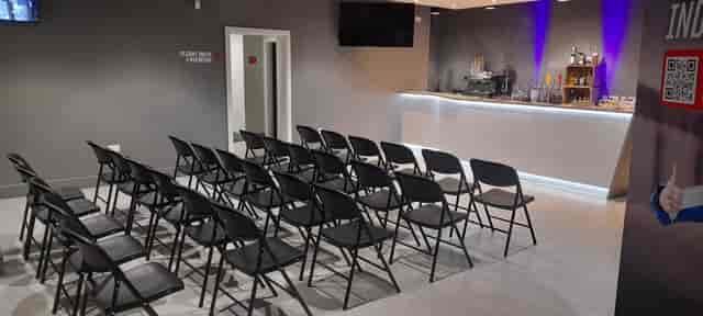 Modern event space at iFLY Indoor Skydiving, featuring a sleek bar and audience seating.