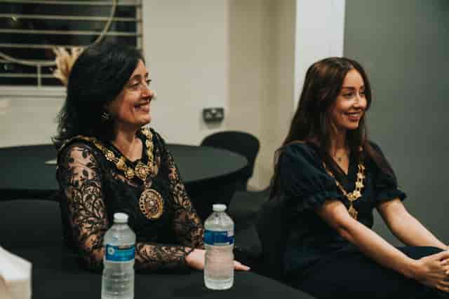 Elegant women networking at Victory Outreach Manchester's Large Function Hall event.
