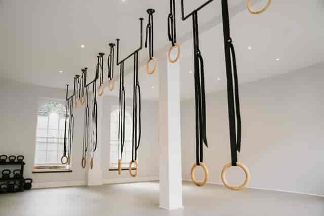 Modern fitness studio with gymnastic rings, perfect for group workouts and wellness events.