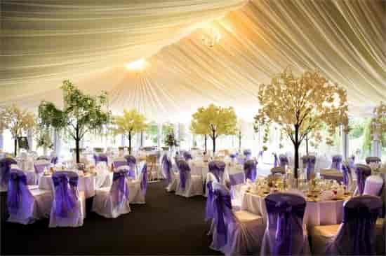 Elegant corporate event space at Nailcote Hall with round tables and purple sashes.