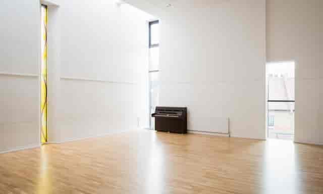 Spacious St John's Church venue with wooden flooring for workshops and gatherings.