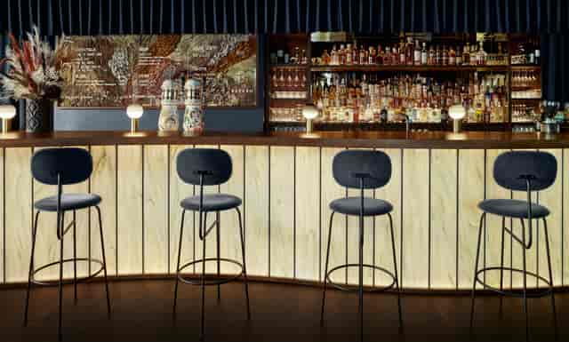 Sleek modern bar with warm lighting for networking events and cocktail receptions.