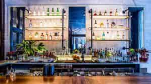 Modern cocktail bar with organized spirits display, perfect for networking events.