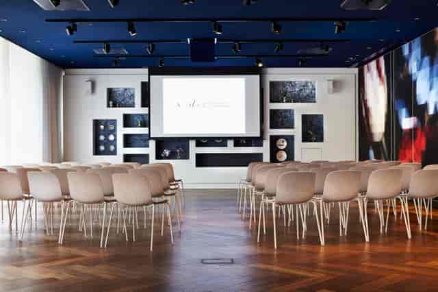 Modern meeting space in Andaz Amsterdam with large screen for corporate events.